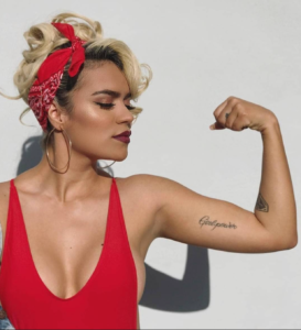 Karol G mostrando su tatuaje que dice "Girl Power" 
